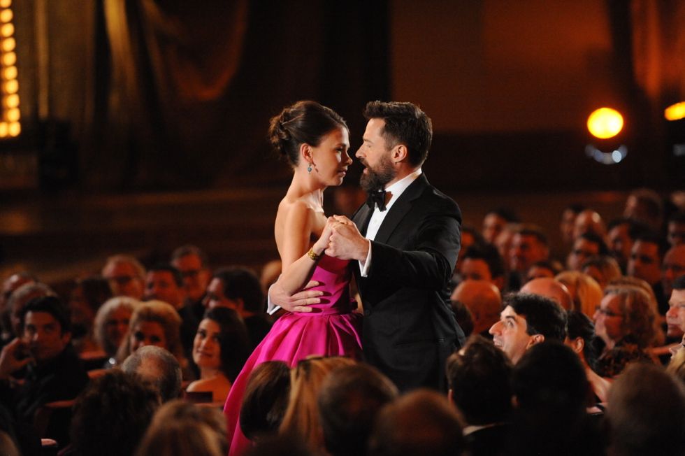 Jackman, in a tux, sings to Foster as he holds her in a ballroom grip in the aisle of a crowded theater.