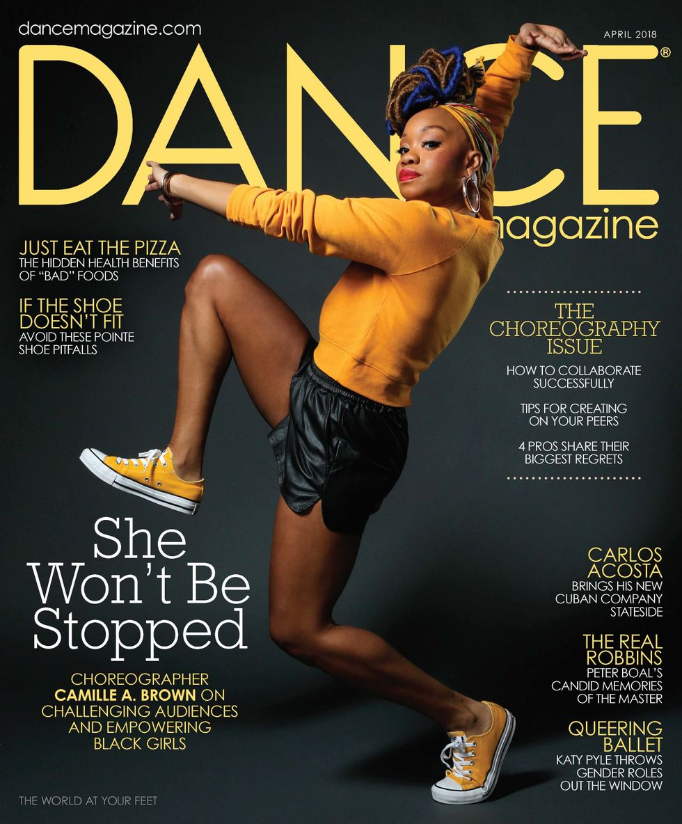Dance Magazine's April cover featuring a triumphant Camille A. Brown in a bright yellow sweater and sneakers