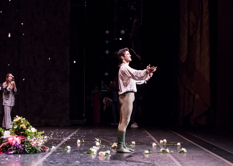 Roberto Bolle surrouneded by flowers on stage