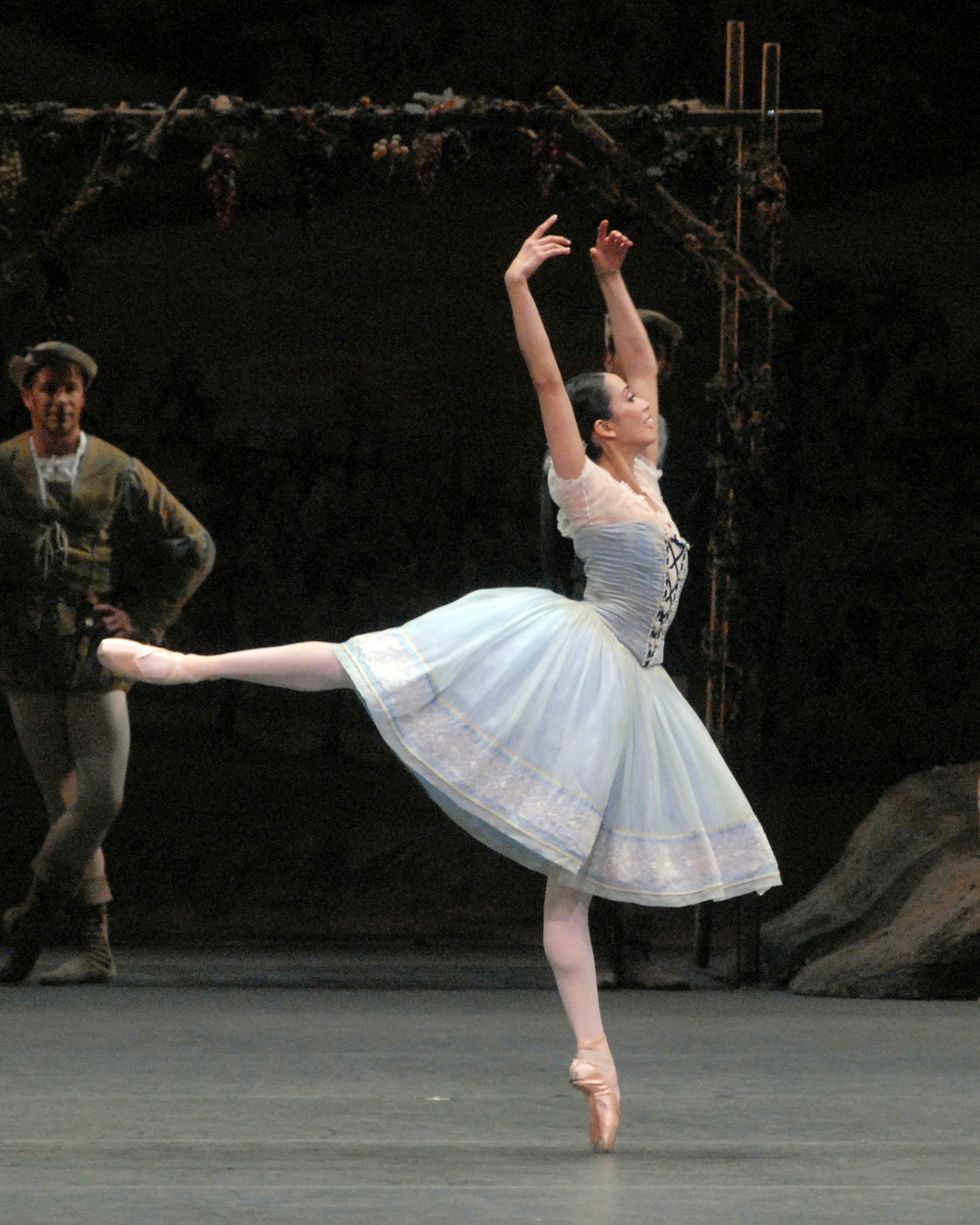 Stella Abrera balances in an open arabesque, arms in high fifth, during the first act of Giselle.