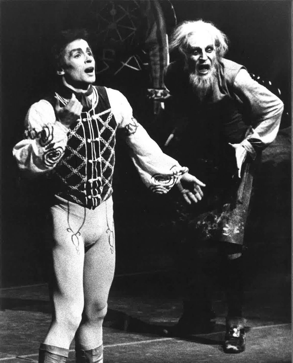 Rudolf Nureyev and Erik Bruhn, in costume as Franz and the eccentric Dr. Coppu00e9lius, respectively, both gesture with their mouths open, as though attempting to speak over one another.