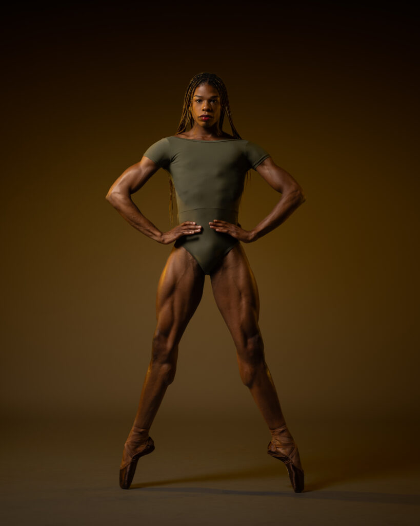 a dancer wearing a green leotard en pointe in a wide second position 