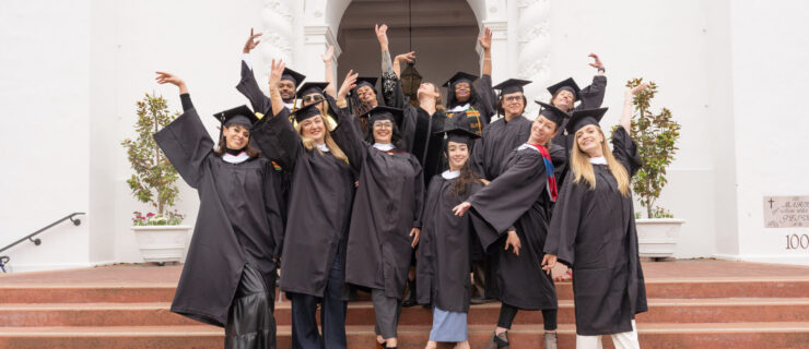 a group of dancers posing on steps wearing graduation caps and gowns