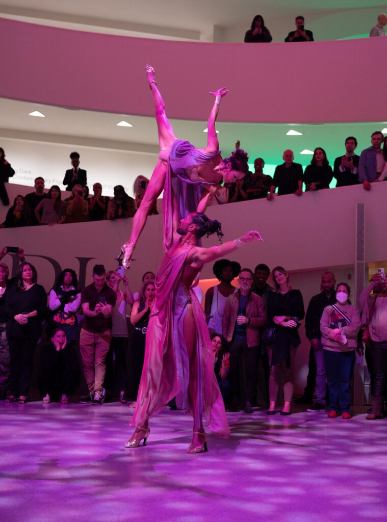 two dancers partnering on the dance floor with one lifting the other over their head