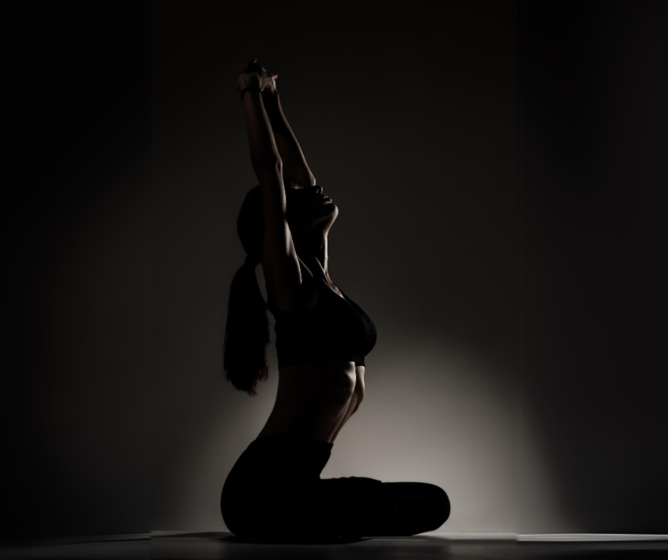 a woman kneeling while stretching her arms above her head