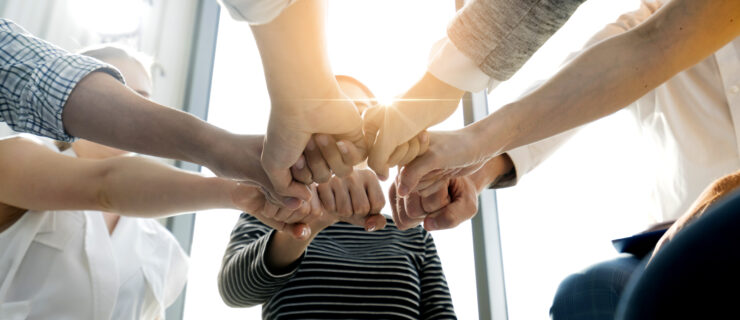 Close up top view of young and freshness energy business people putting their strong hands together. Stack of friendship hands. Unity and successful teamwork concept.