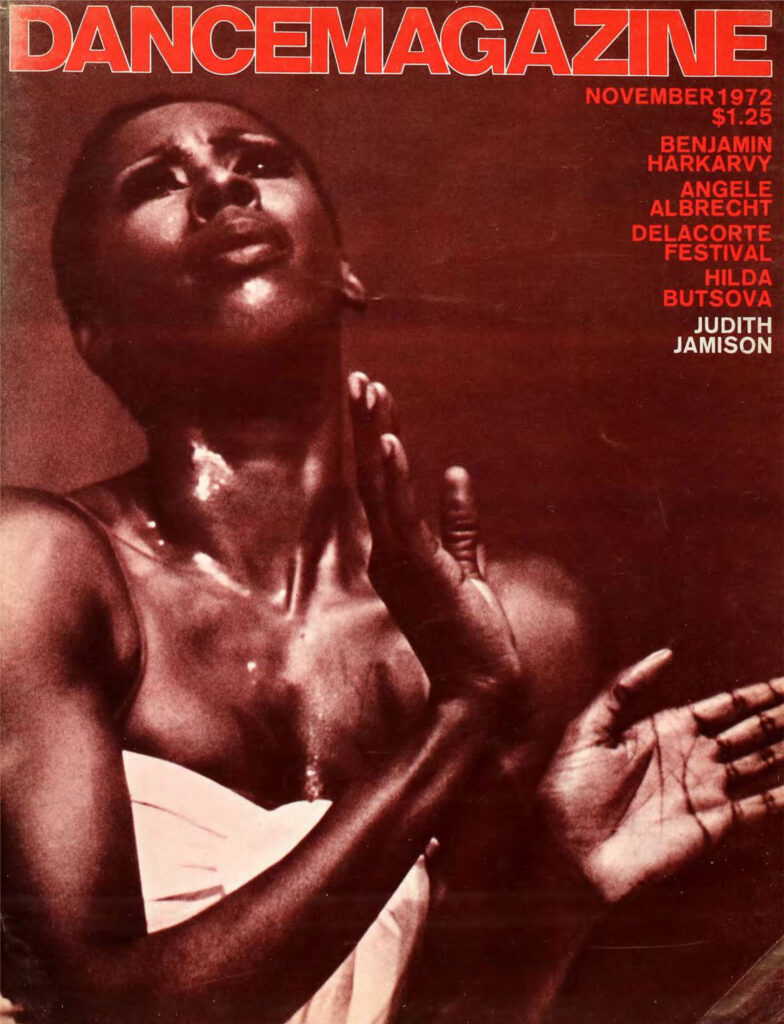 A magazine cover featuring a photo of Jamison, a dark-skinned Black woman with close-cropped hair wearing a white strapless top, pictured from the waist up. Her hands are held elegantly in front of her chest and her eyes are gazing upward. The Dance Magazine logo is printed in red across the top of the image.