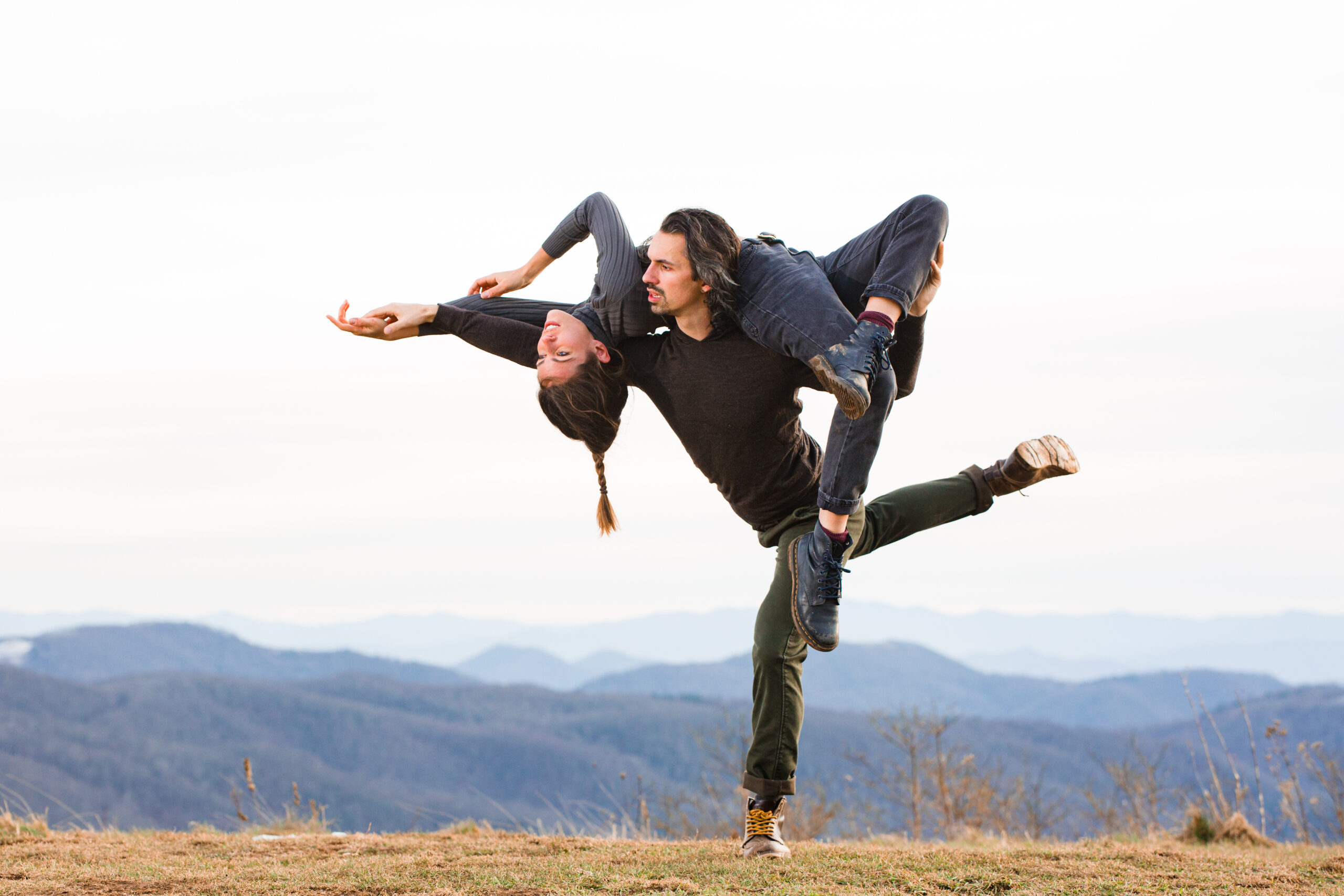 Gavin Stewart holding Vanessa Owen on his shoulders as they dance outdoors against a scenic background