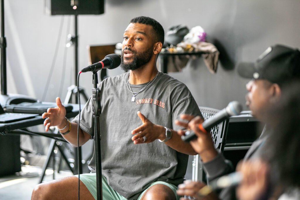 Du’Bois A’Keen singing into a mic during rehearsal 