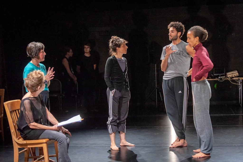 Netta Yerushalmy (center) in conversation with collaborators during a technical residency rehearsal of PARAMODERNITIES at NCCAkron.