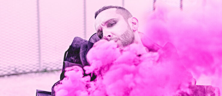 Manuel Liñán gazes at the camera, face mostly hidden by a cloud of fuchsia tulle.