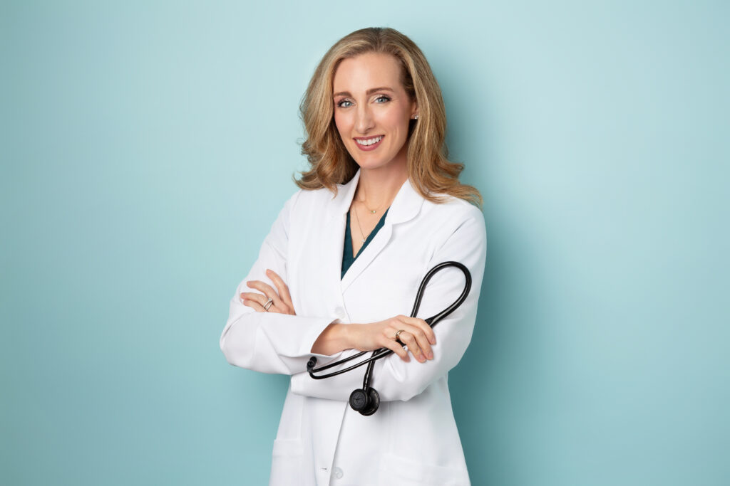 A female doctor wearing a white lab coat and holding a stethoscope. 