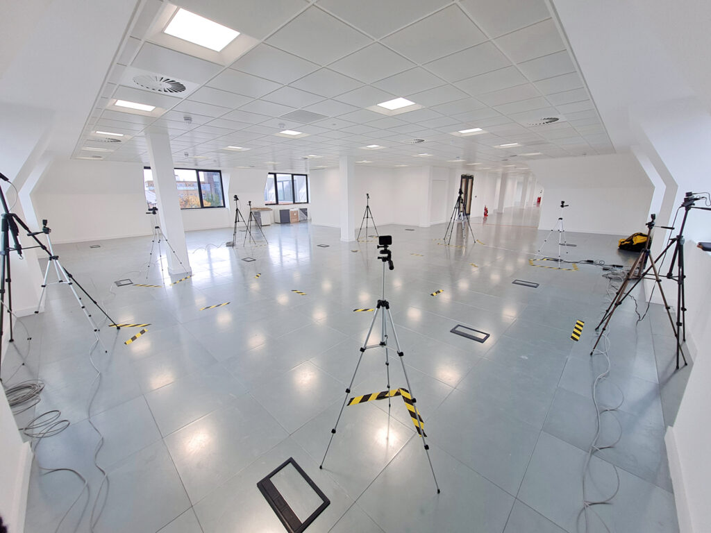A white room with multiple cameras on tripods set up all around. 