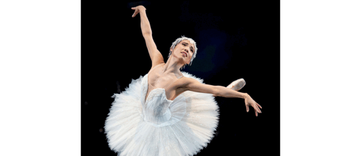 Frances Chung in Swan Lake. She wears a white tutu and head piece. She performs an attitude derrière on stage.