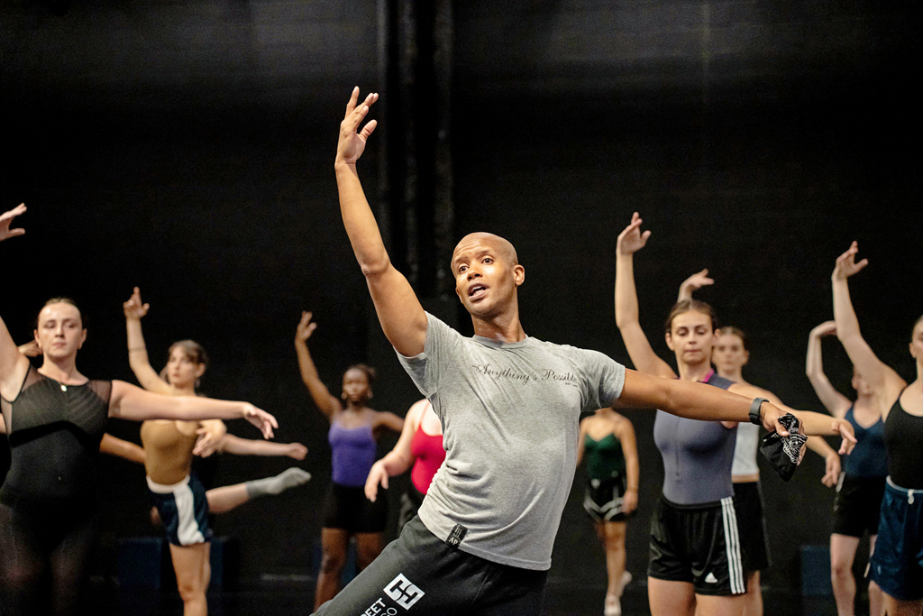 Jonathan Alsberry teaching class to a group of female students. He performs an attitude derrière while the dancers behind him follow.
