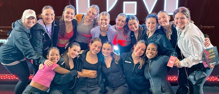 Danielle O’Brien huddles together for a group photo with teenage dancers.