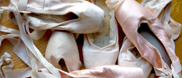 A group of well-worn ballet shoes.