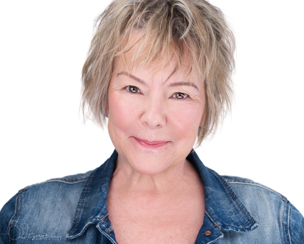 Rice—wearing a denim button-down shirt, her light hair in a choppy bob—gives the camera half a smile.